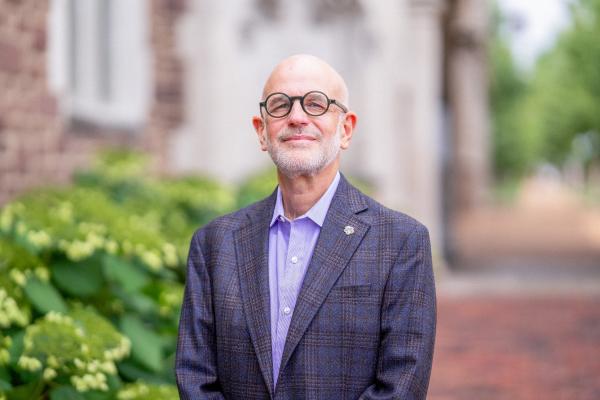 Jonathan Judaken, Goldstein Professor of Jewish History and Thought, pictured in a blue suit, smiles at the camera.