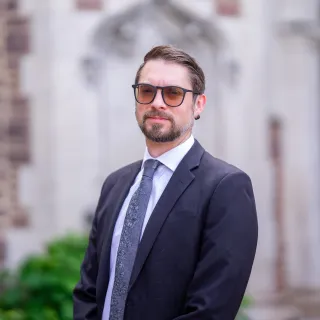 Image of Assistant Professor Dalen Wakely-Smith in a suit and tie.